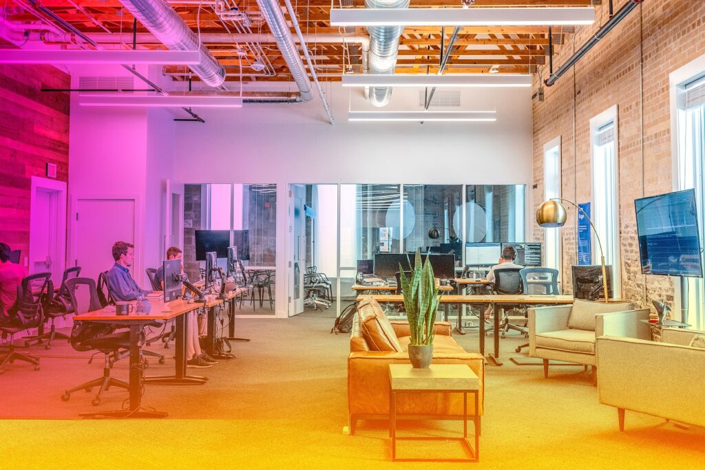 An interior of an office with people working on computers at desks.