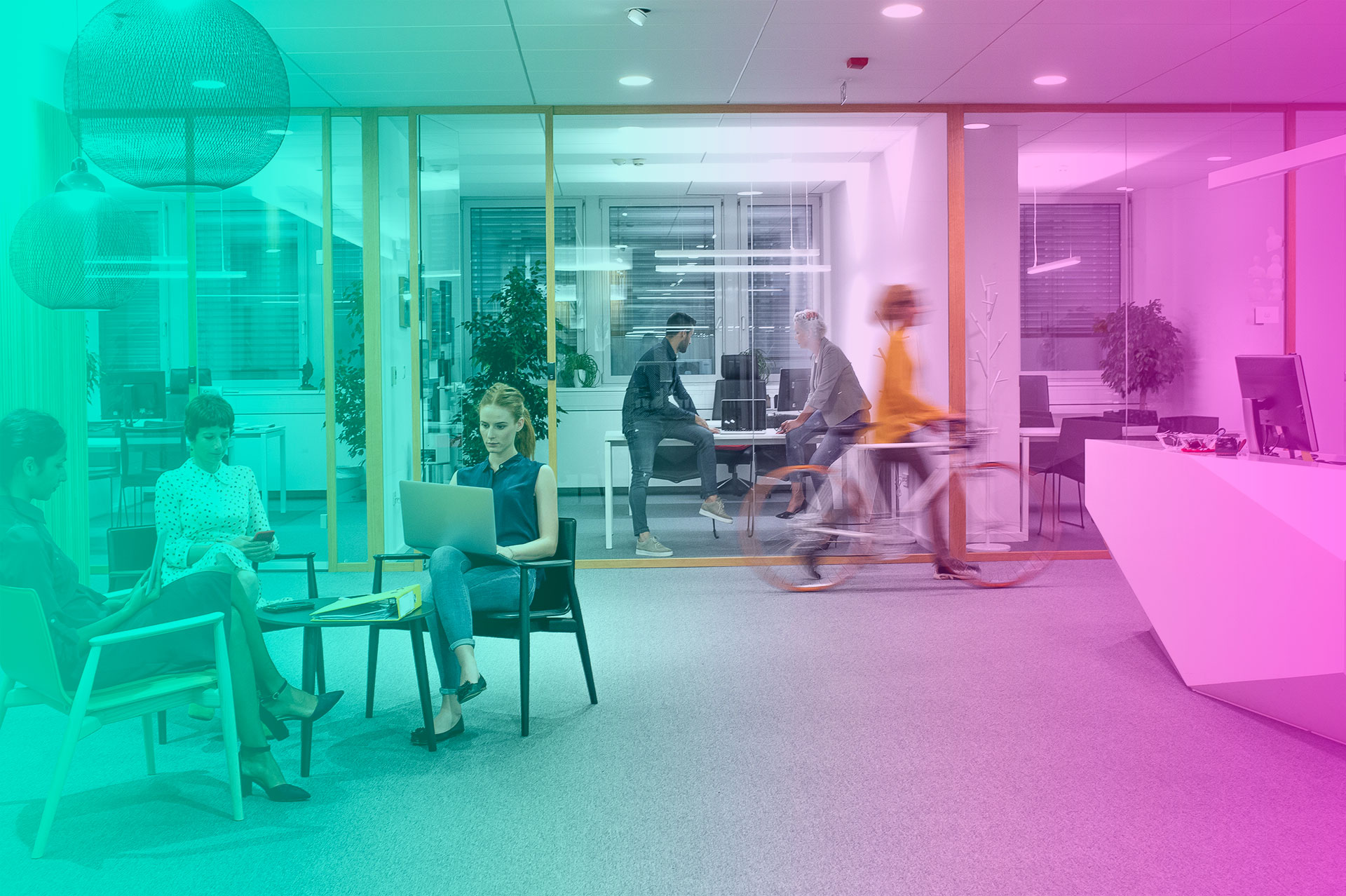 Interior of an office with people sat together working.