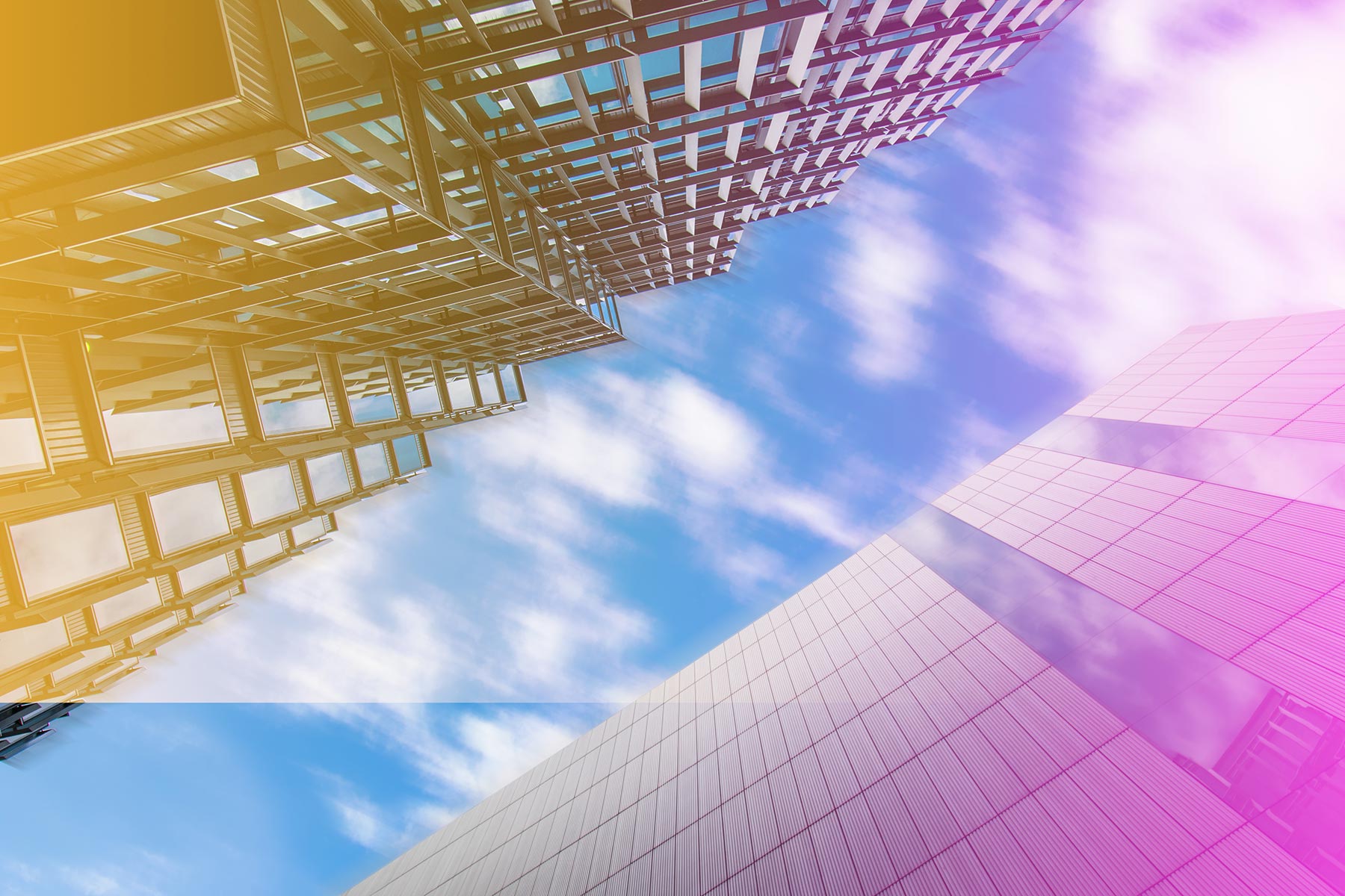 Skyscraper buildings from a low angle with a blue sky above.