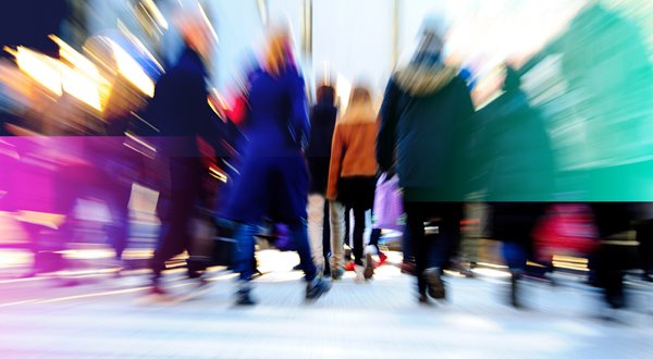 A crowd of people walking on a city street.