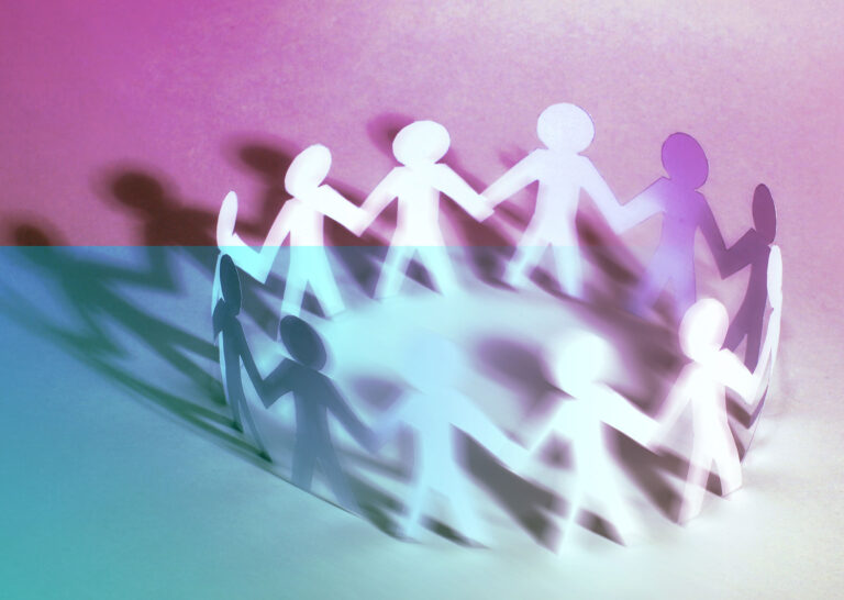 Circular paper chain of people holding hands.