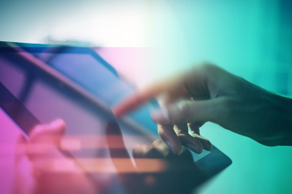 Hand touching and signing a tablet.