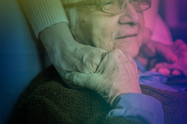 Old woman holding hands with a younger person.