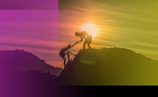 A person helping another person climb a mountain.