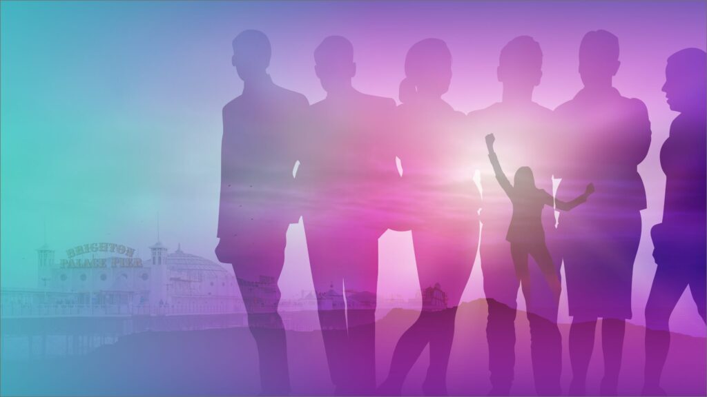 People standing in a group in front of Brighton Pier.