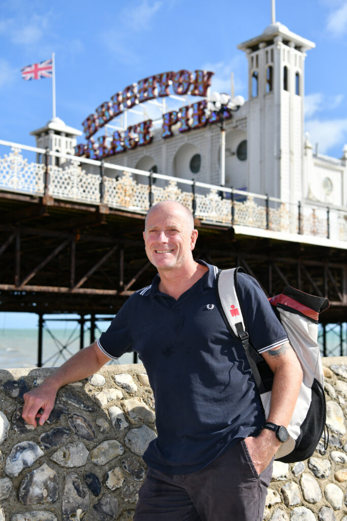 DMH Stallard Partner David Bailey standing in fornt of Brighton Pier to promote his English Channel charity swim